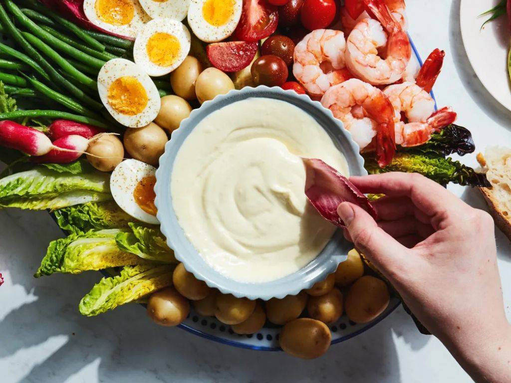 Aioli je klasická francúzska omáčka, ktorá je známou lahôdkou v stredomorskej kuchyni. Svojou základnou ingredienciou, olivovým olejom, cesnakom, vajíčkom a citrónom, ponúka krémovú a aromatickú textúru, ktorá dokonale dopĺňa rôzne jedlá. Tento lahodný dressing je ideálny na ryby, grilované mäso alebo zeleninu, no skvele sa hodí aj ako dip k čerstvému chlebu alebo ako prísada do šalátov.