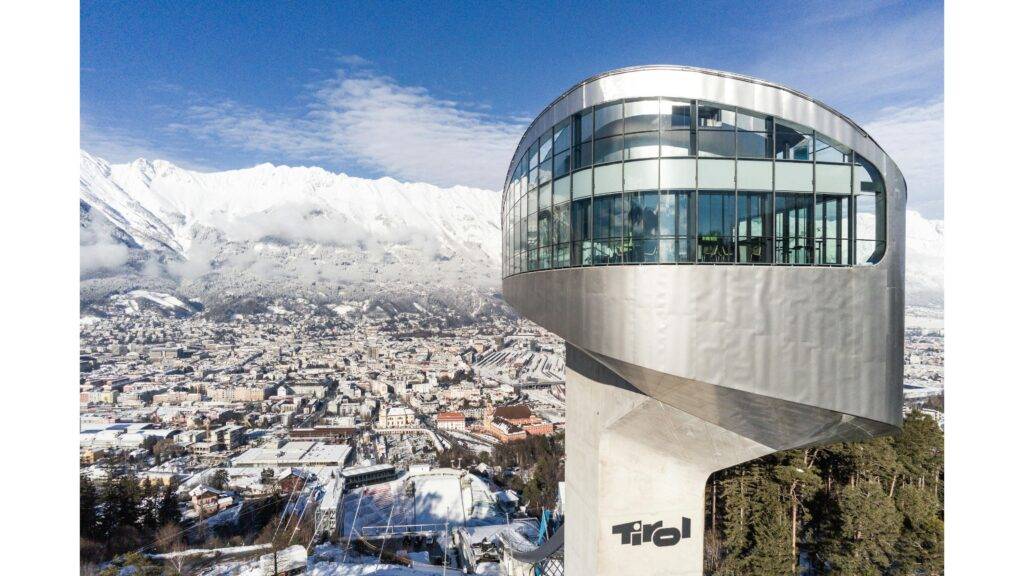Bergisel Ski Jump v Innsbrucku je jedným z najznámejších a najimpozantnejších skokanských mostíkov na svete. Nachádza sa v srdci rakúskych Álp a ponúka návštevníkom jedinečný výhľad na mesto Innsbruck a jeho okolie. Tento moderný skokanský mostík je postavený na mieste, kde sa konali zimné olympijské hry v rokoch 1964 a 1976. Vďaka svojej výnimočnej architektúre a technickým inováciám sa stal jedným z najväčších symbolov rakúskej lyžiarskej tradície. Mostík, navrhnutý svetoznámym architektom Zaha Hadid, sa vyznačuje futuristickým dizajnom a pôsobivými sklony, ktoré umožňujú skokanom dosahovať úžasné výšky.