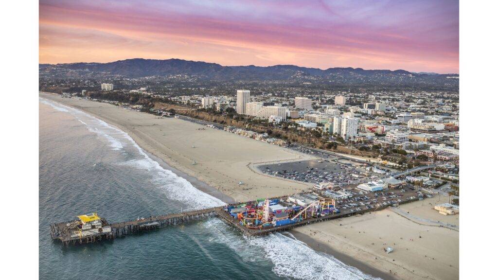 Santa Monica je ikonické kalifornské mesto, ktoré sa nachádza na pobreží Tichého oceánu a je jedným z najpopulárnejších turistických cieľov v regióne. S jeho nádhernými plážami, slnečnými dňami a živou atmosférou je miestom, kde sa stretávajú turisti, miestni obyvatelia a milovníci vodných športov. Pláž Santa Monica je známa svojimi jemnými piesočnými brehmi a priezračnou vodou, ktorá láka ľudí na relaxáciu, surfing alebo len na prechádzky po pláži. Okrem pláže mesto ponúka aj moderné reštaurácie, butiky a kultúrne atrakcie, čo robí zo Santa Monica obľúbený cieľ pre každého, kto túži zažiť kalifornský spôsob života.