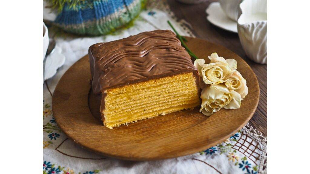 Baumkuchen je jedinečný vrstvený koláč, ktorý svojím vzhľadom pripomína letokruhy stromu, odkiaľ pochádza aj jeho názov – doslova „stromový koláč“. Tento tradičný dezert má svoje korene v Nemecku, kde je známy už niekoľko storočí, a postupne si získal popularitu v celej Európe. Jeho príprava je náročná, pretože cesta sa pečie v niekoľkých tenkých vrstvách na rotujúcom valci, čím vzniká charakteristický vzor, ktorý koláč robí tak jedinečným a esteticky príťažlivým.