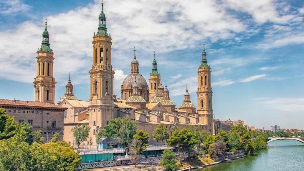 Zaragoza, hlavné mesto regiónu Aragónia, leží na strategickom mieste medzi Madridom a Barcelonou, priamo na brehu rieky Ebro. Jej dejiny siahajú do čias Rimanov, Maurov aj kresťanských kráľov, čo sa odráža na rozmanitej architektúre a kultúre mesta. Historické pamiatky, ako rímske divadlo, mestské múry či stredoveké kostoly, robia zo Zaragozy miesto, kde sa prelína niekoľko civilizácií.
